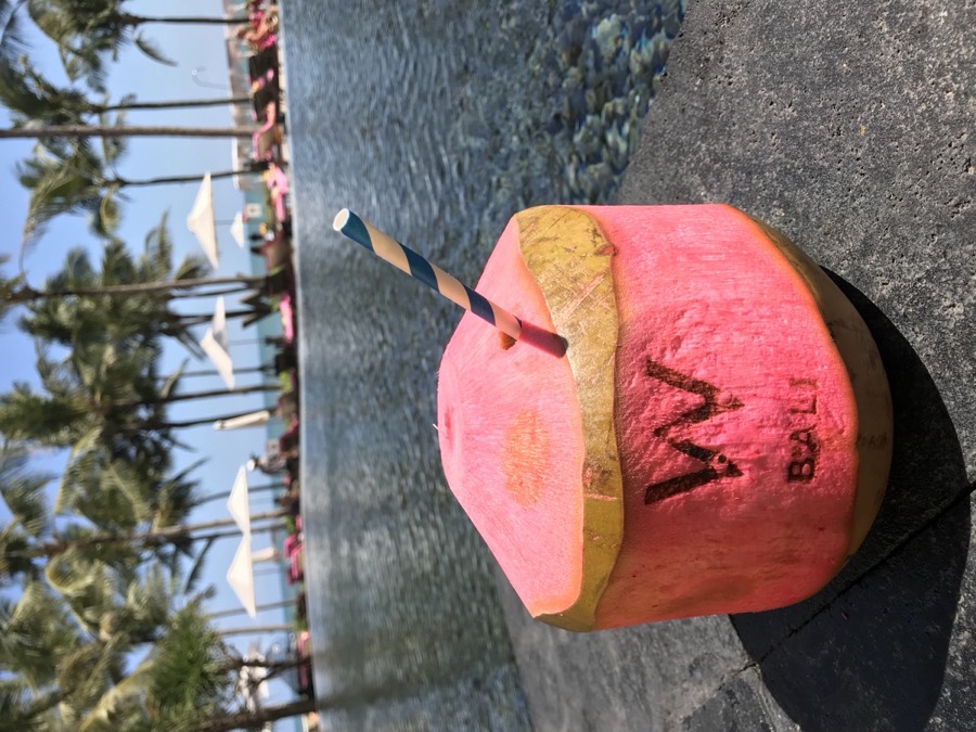 A pink coconut by a pool in Bali